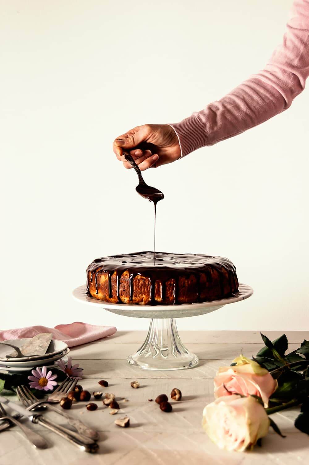 Una persona está cubriendo una tarta con ganache de chocolate con agua fácil.