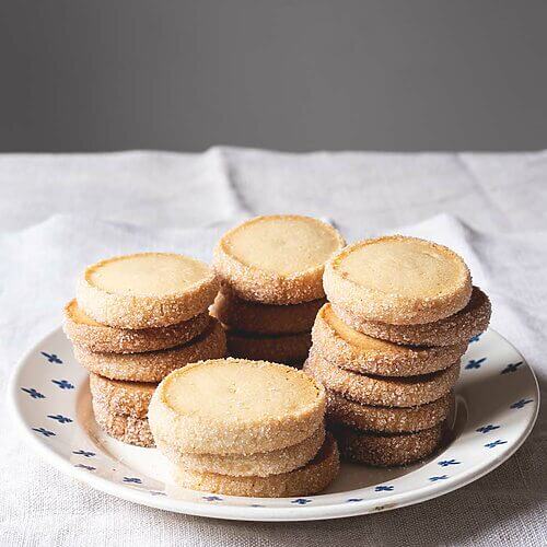 En una mesa hay un mantel blanco. Encima hay un plato vintage. En el plato hay cuatro torres de Galletas Diamante. Se ven muy crujientes.