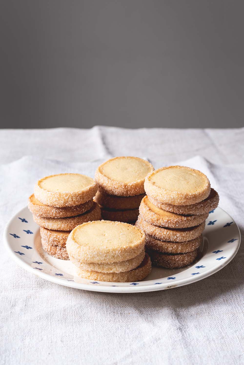 En una mesa hay un mantel blanco. Encima hay un plato vintage. En el plato hay cuatro torres de Galletas Diamante. Se ven muy crujientes.